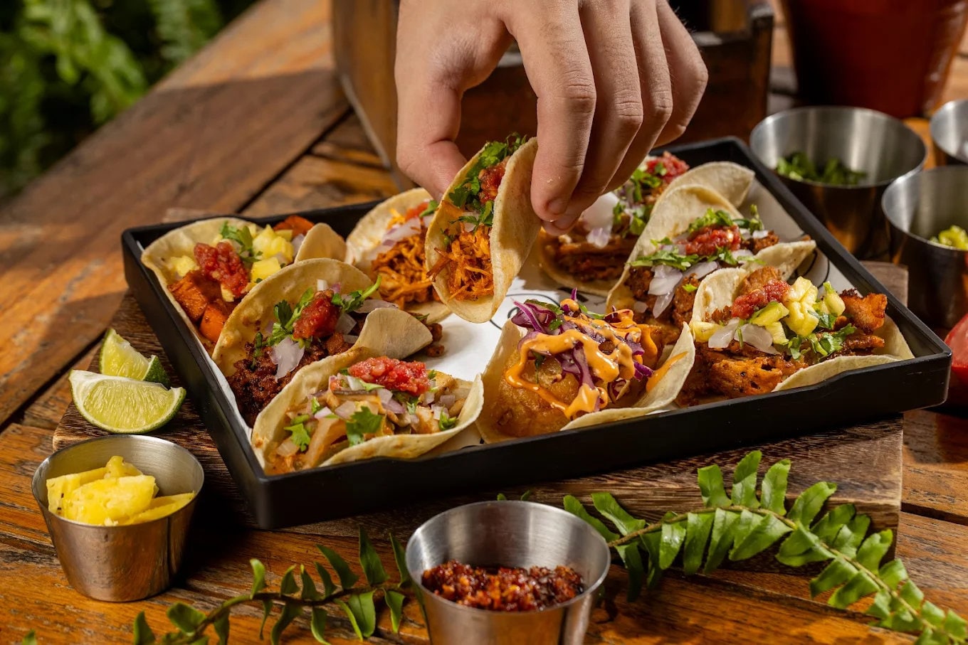 A tray of signature tacos at Naco Taco with diverse fillings on handmade tortillas